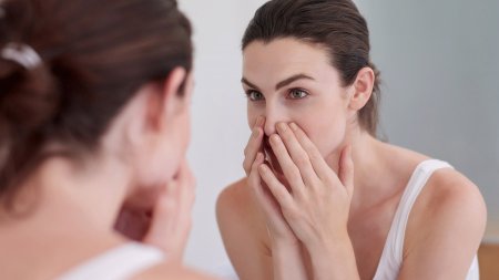 Woman looking at her skin in the mirror