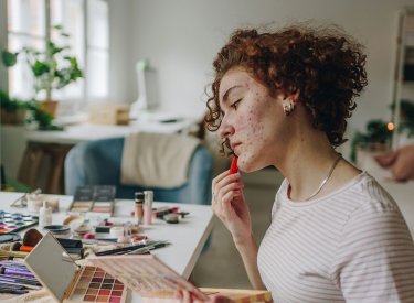woman applying make-up on acne prone skin